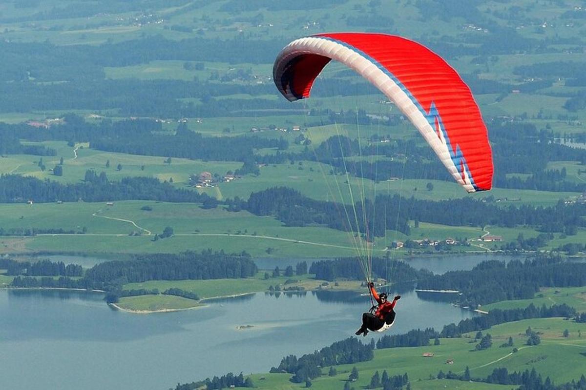 osoba letící na padáku nad vodní plochou