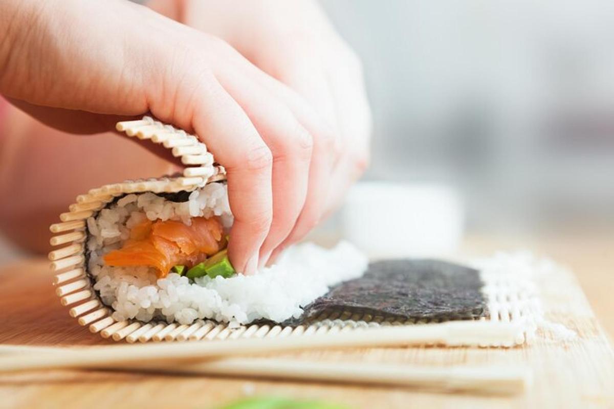 osoba drží kus sushi
