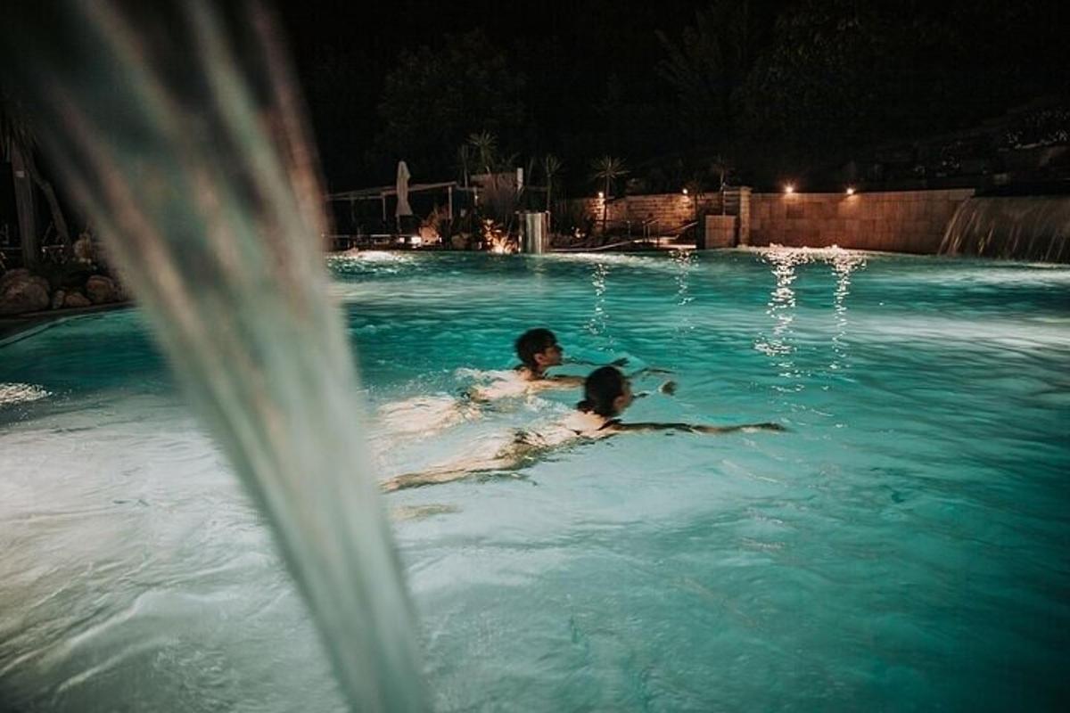 due persone che nuotano in una piscina di notte