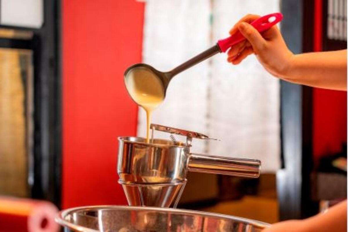 a person using a spoon to stir a container
