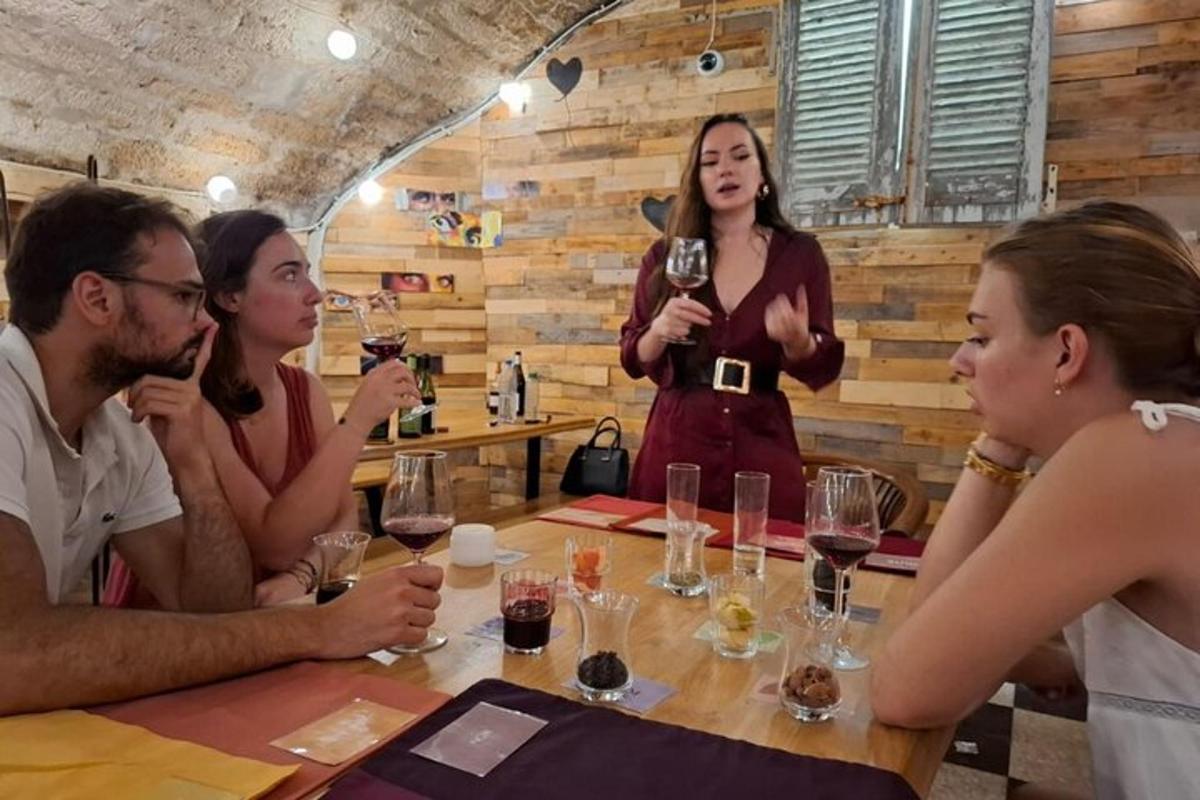 eine Gruppe von Menschen sitzt um einen Tisch und trinkt Wein