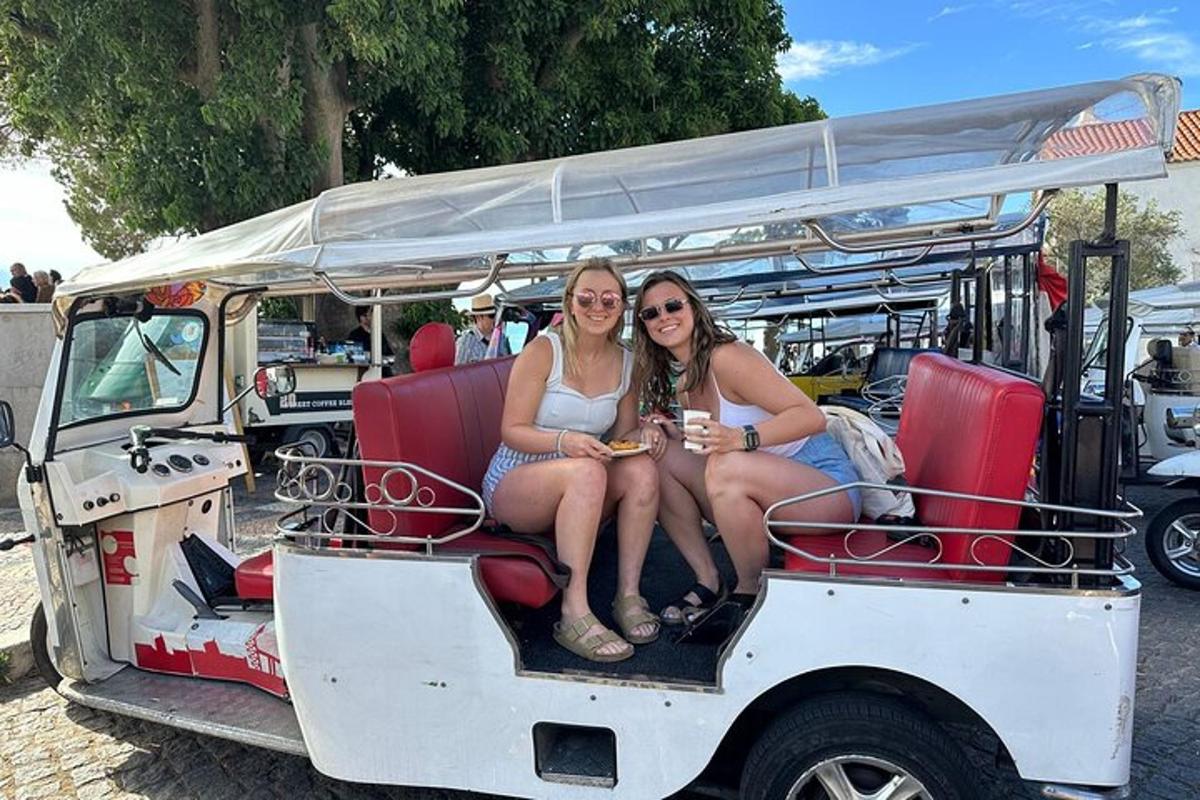 due donne sedute sul retro di un golf cart