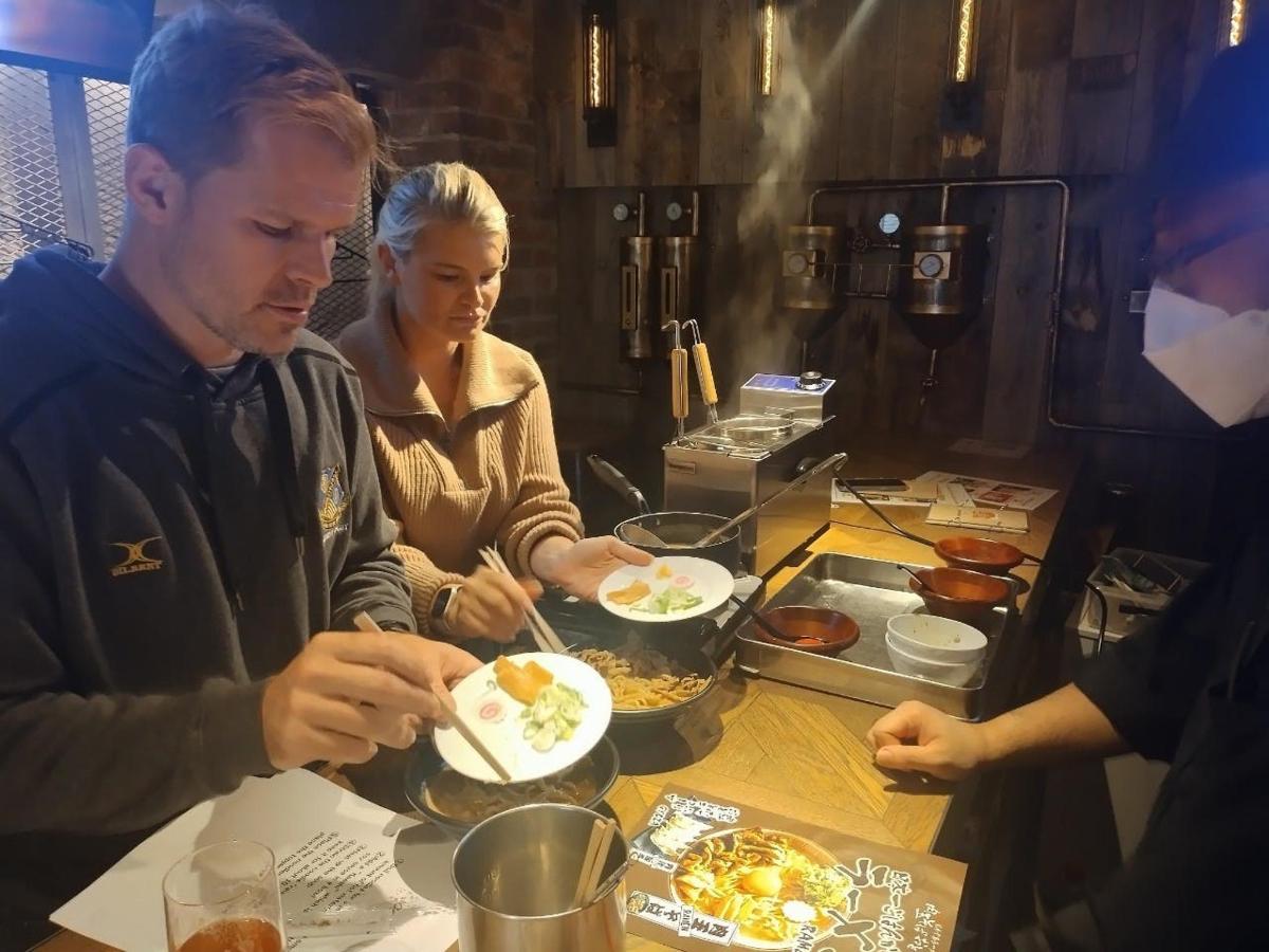 テーブルに座って食事をしている人々のグループ