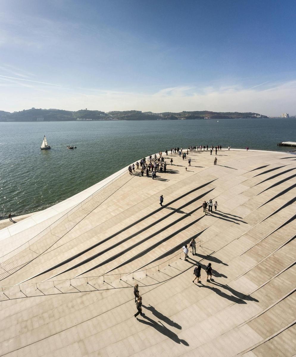 a group of people walking on a pier near the water