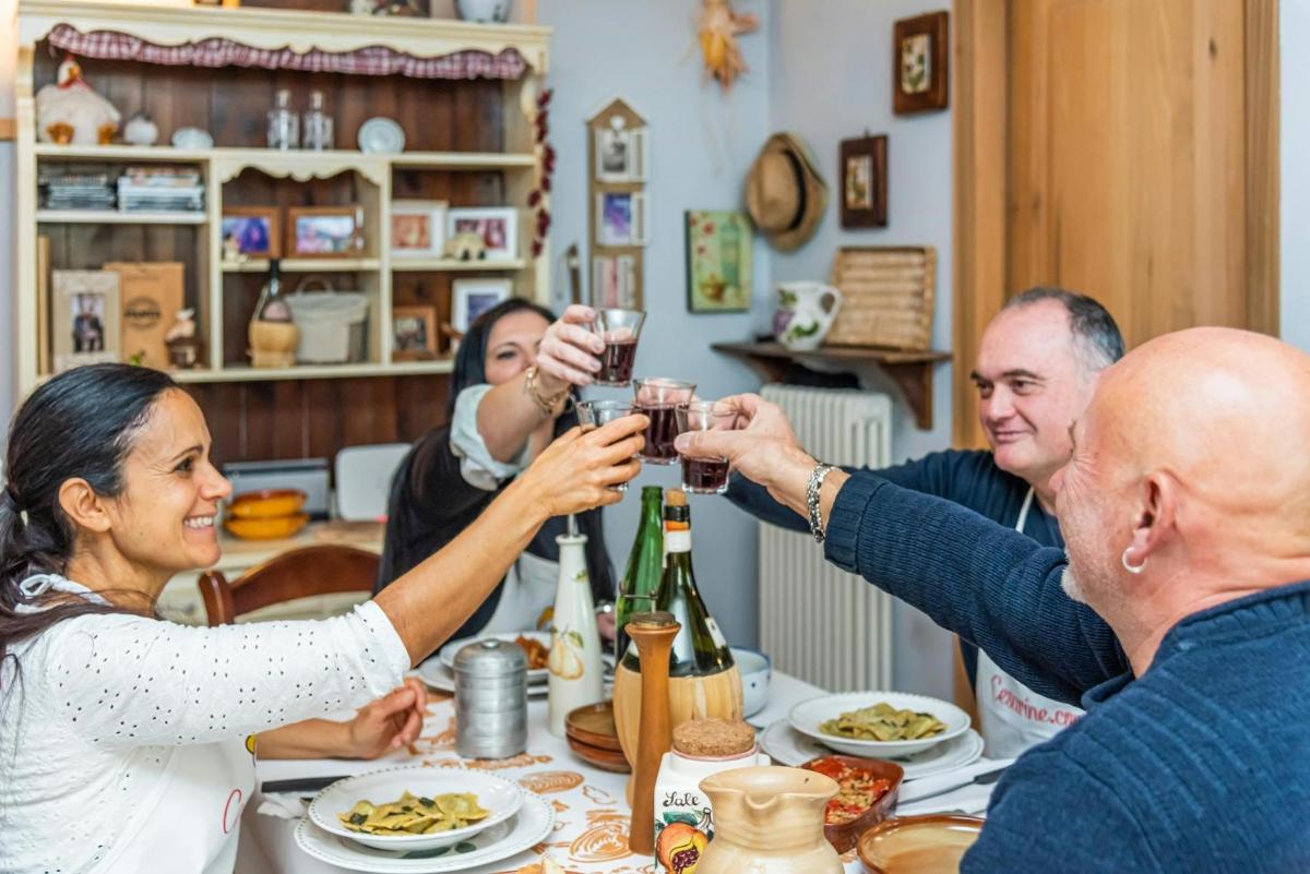 un gruppo di persone sedute attorno a un tavolo che bevono vino
