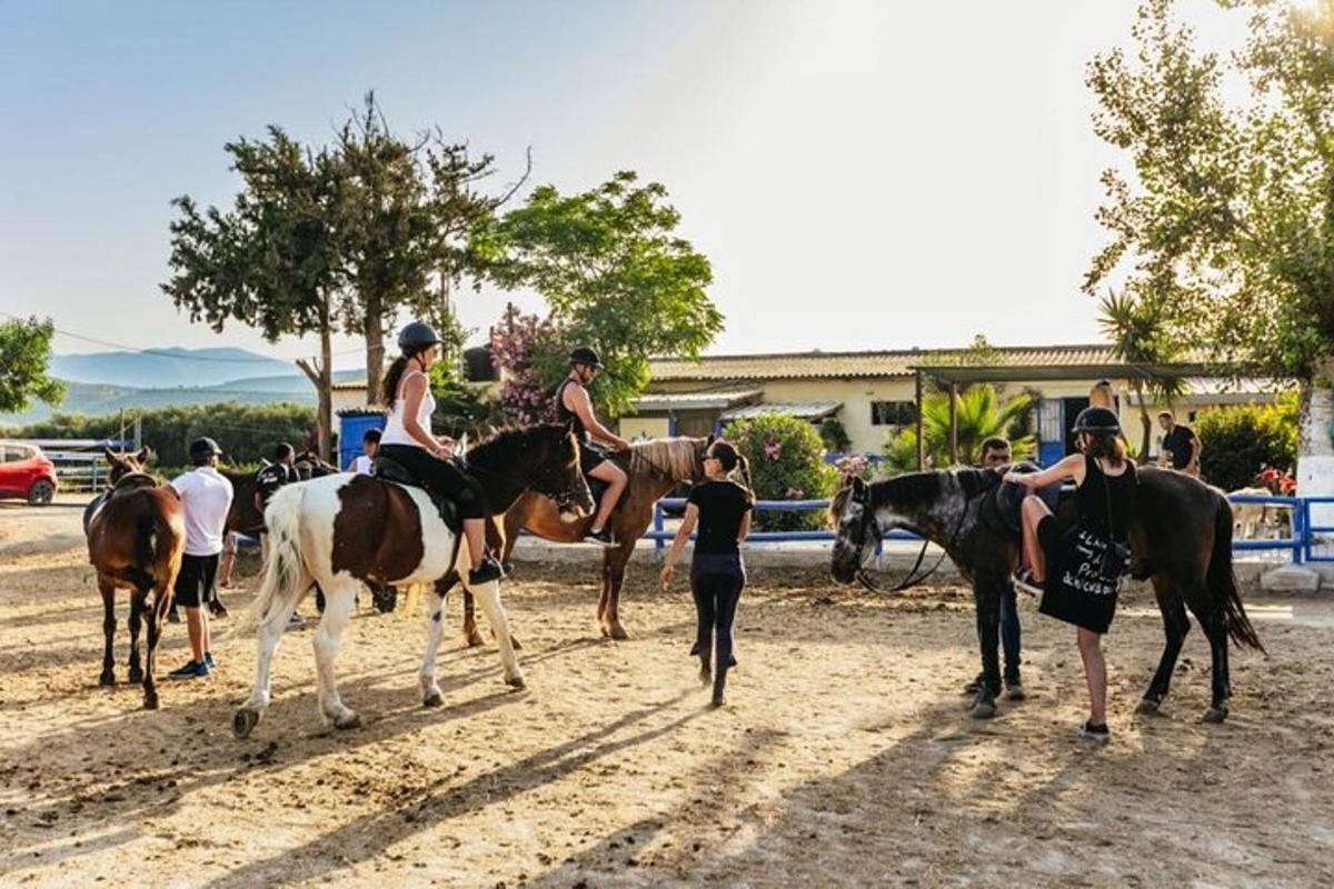 a group of people riding horses on a dirt road