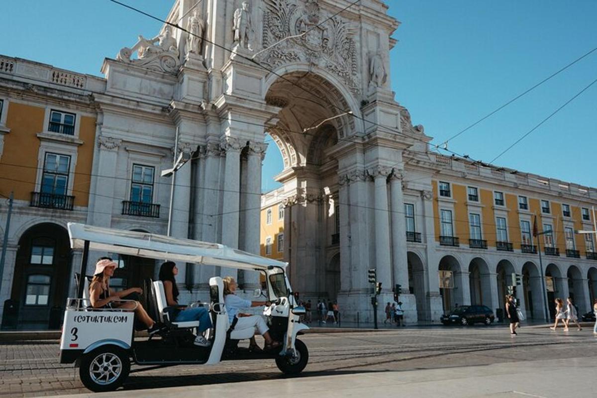 hai người đang đi xe golf trước một tòa nhà