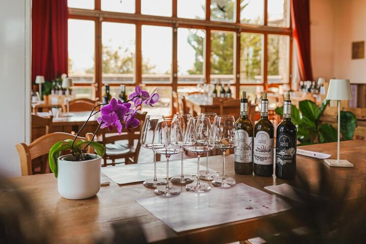 una mesa de madera con vasos y botellas de vino