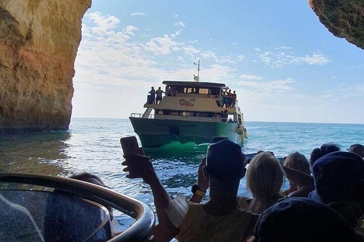 skupina ljudi, ki fotografirajo čoln v oceanu