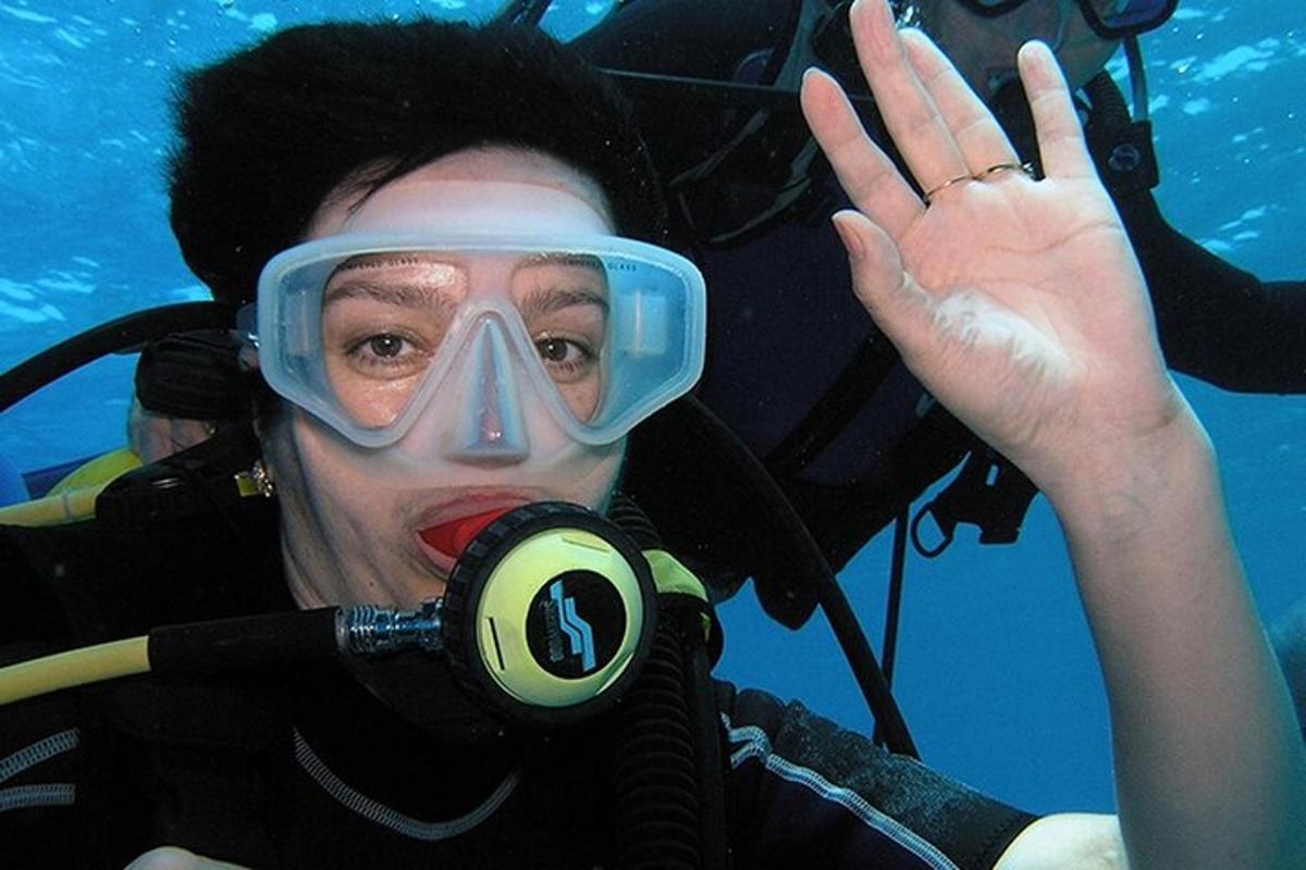 a woman wearing a diver mask and goggles underwater