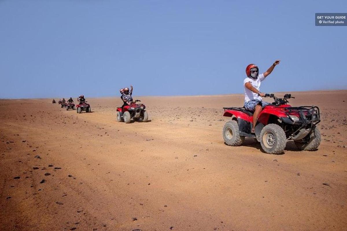 un gruppo di persone in sella a quad nel deserto