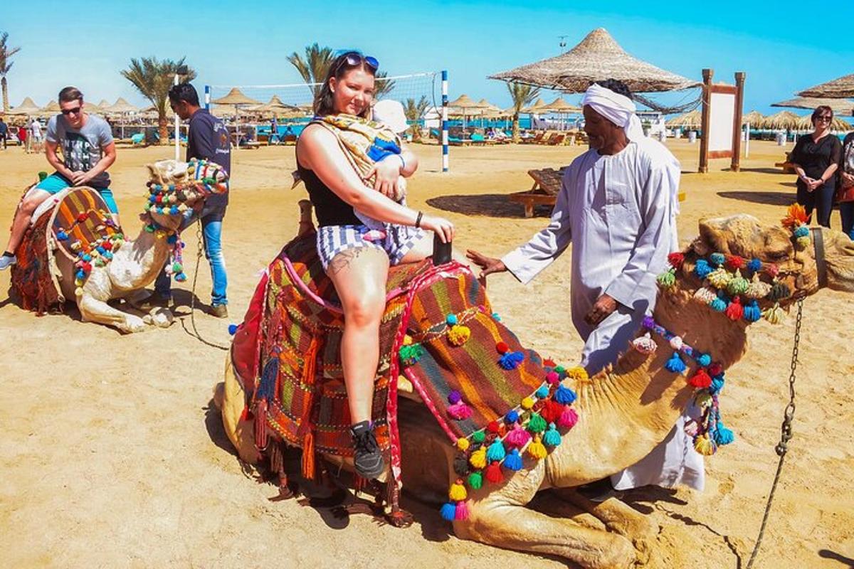 una donna seduta su un cammello sulla spiaggia