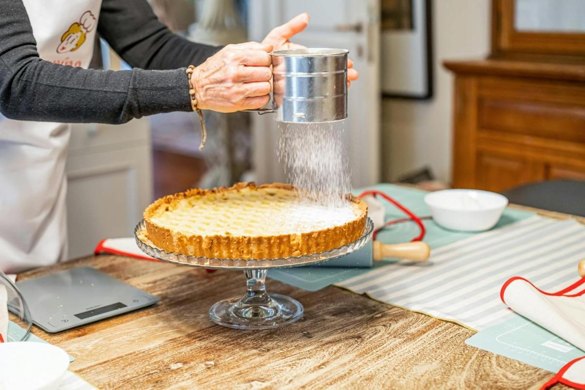 una persona sta versando la glassa su una torta su un tavolo