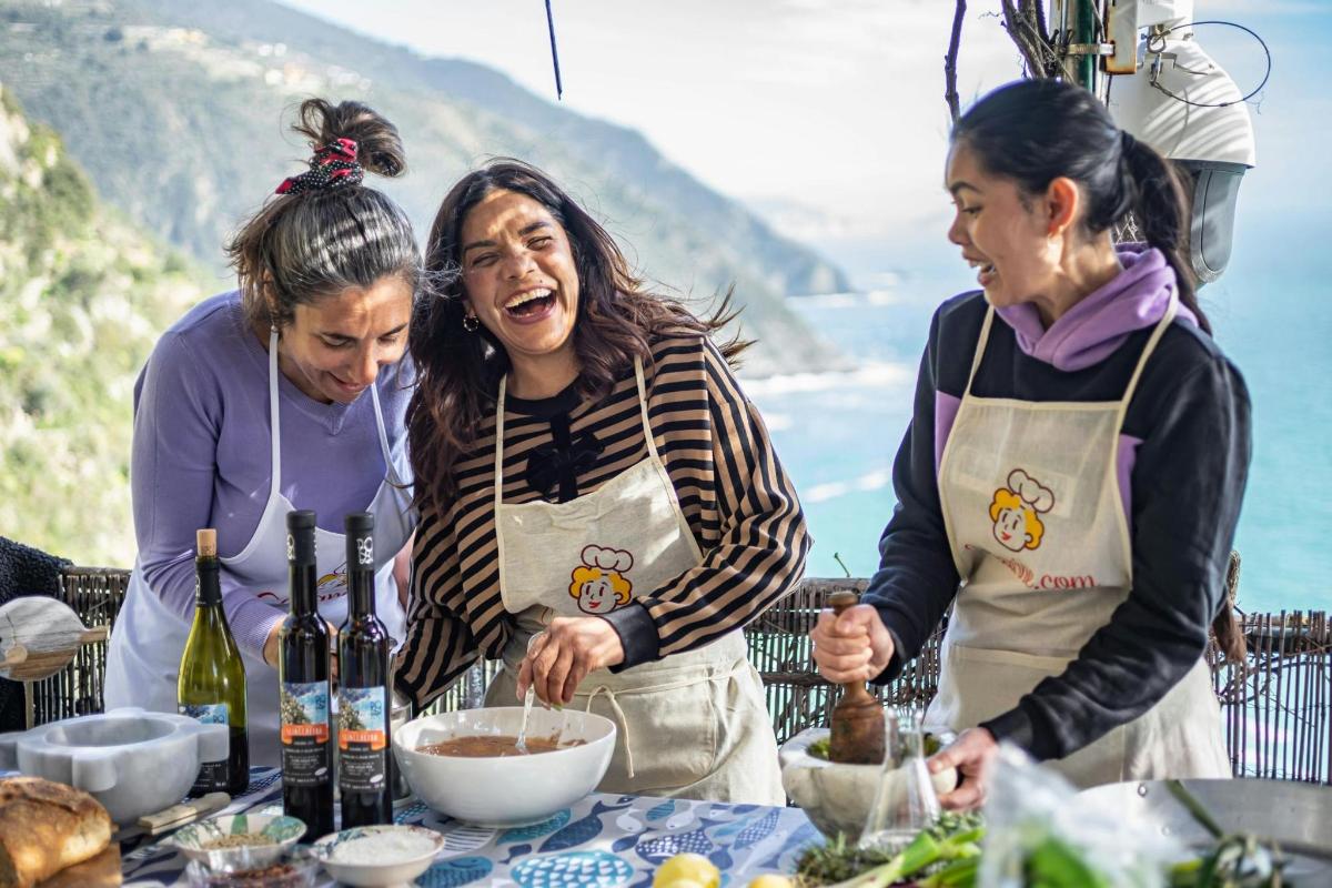 un gruppo di tre donne che preparano il cibo a un tavolo