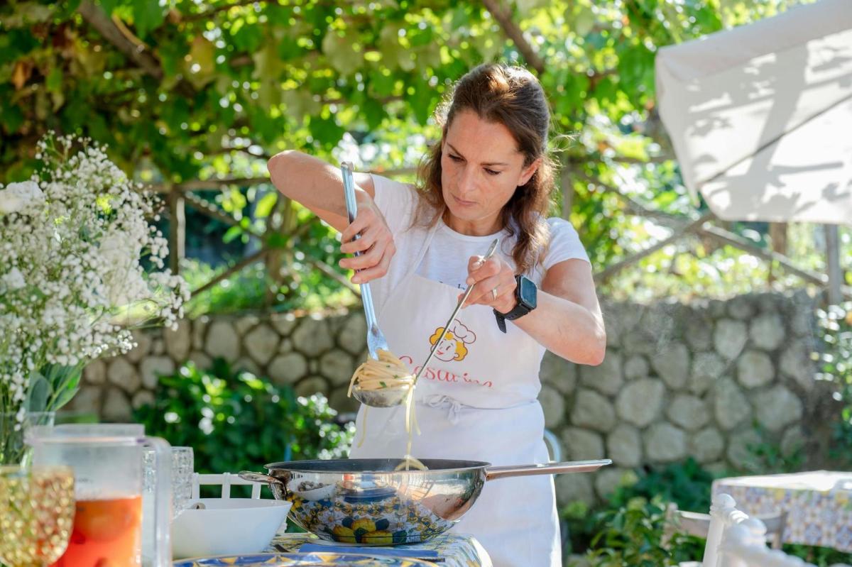 Μια γυναίκα ανακατεύει ένα μπολ με φαγητό με λαβίδα