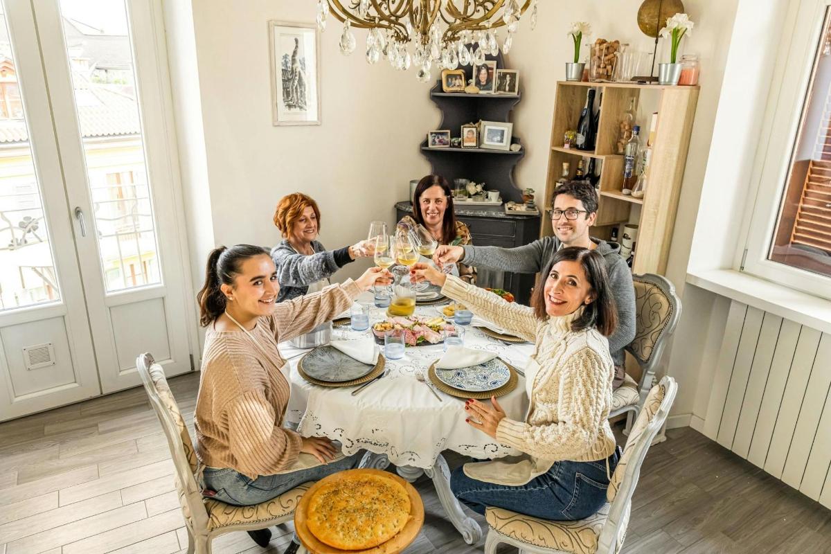 grupp inimesi istub laua ümber ja joob veini