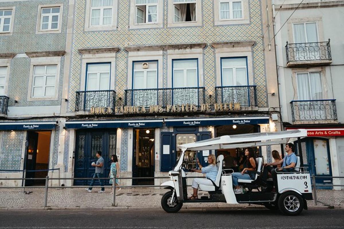 Un carrito de golf circulando por una calle frente a un edificio.