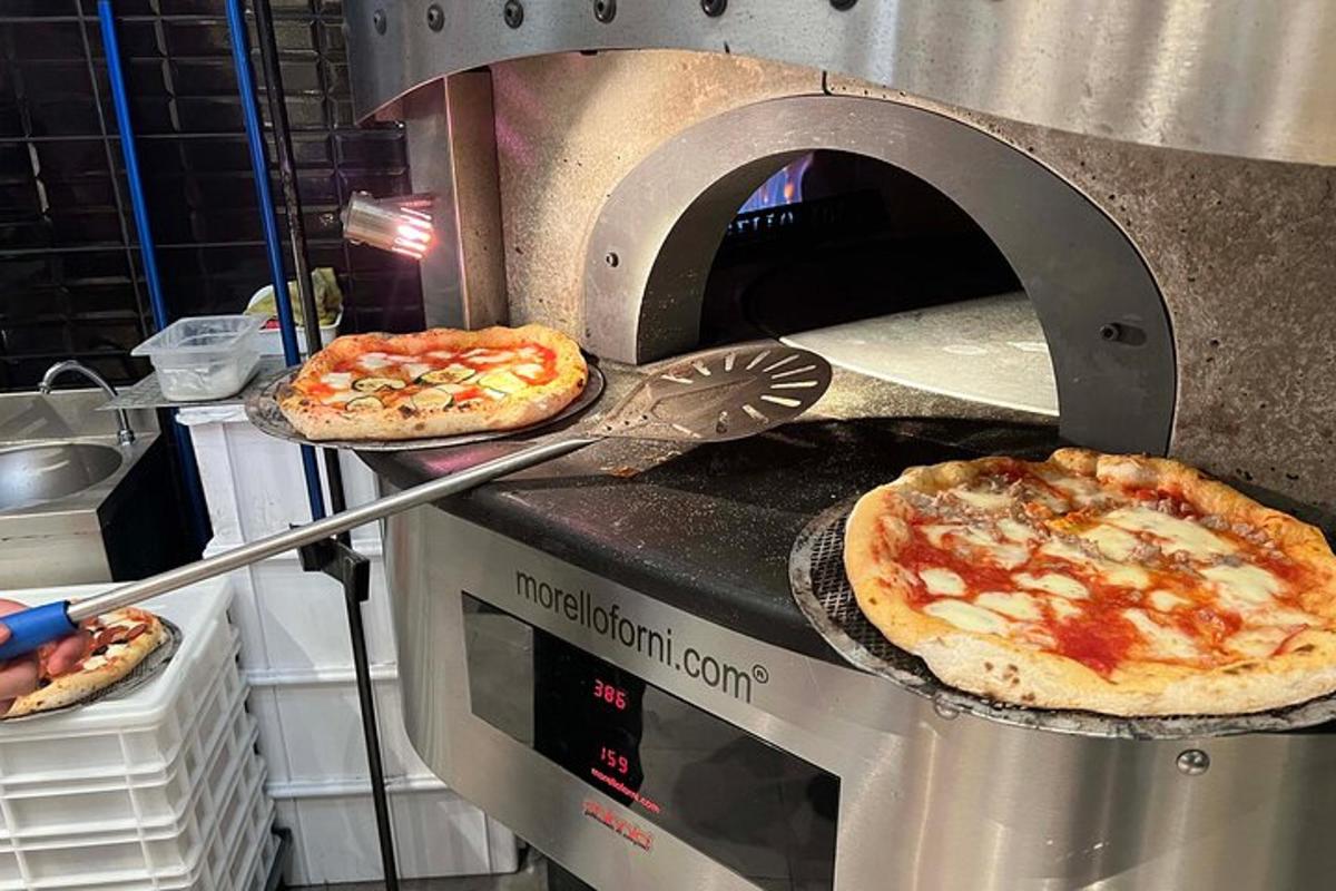 két pizzát sütnek egy pizzakemencében