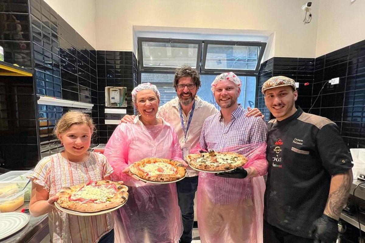 egy csoport rózsaszín ruhás ember pizzákat tart a kezében