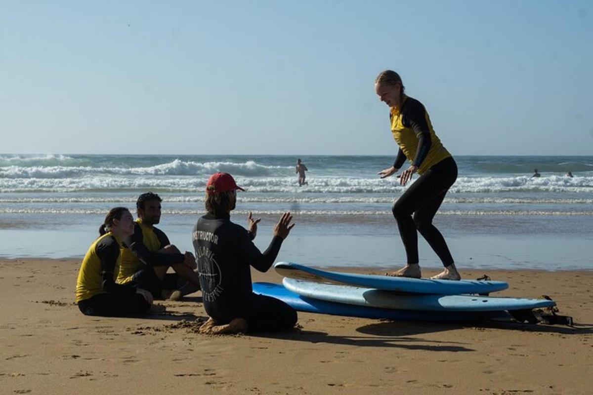 Un grupo de personas sentadas en la playa con tablas de surf