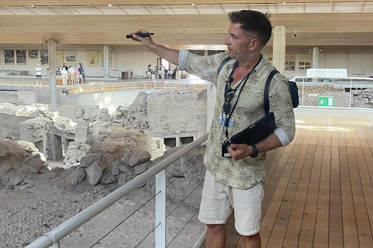 a man with a camera pointing at a display of rocks