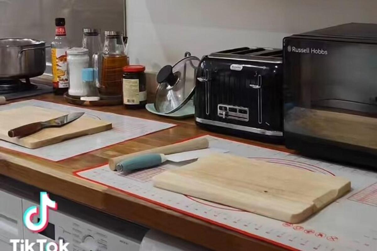 kaunter dapur dengan papan pemotong dan ketuhar gelombang mikro