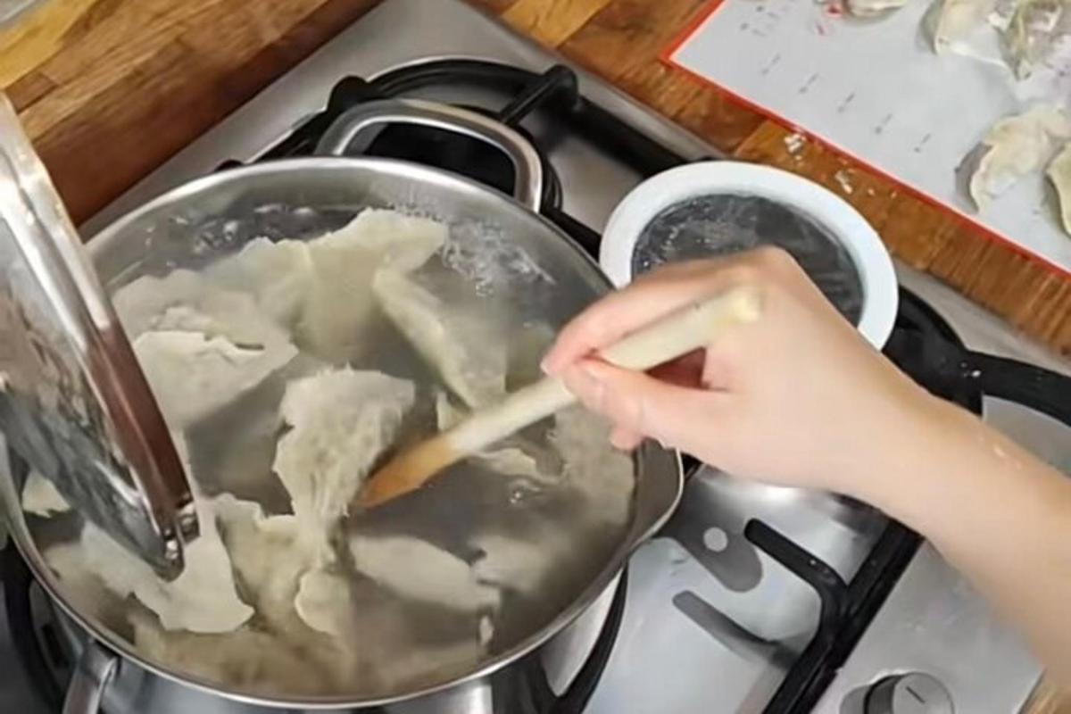 una persona revolviendo una olla de comida en una estufa