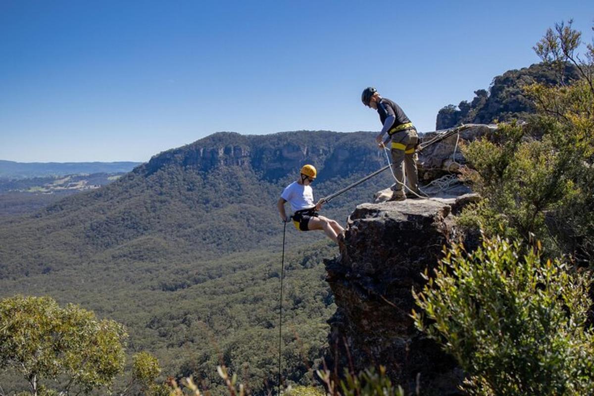 two people standing on top of a cliff