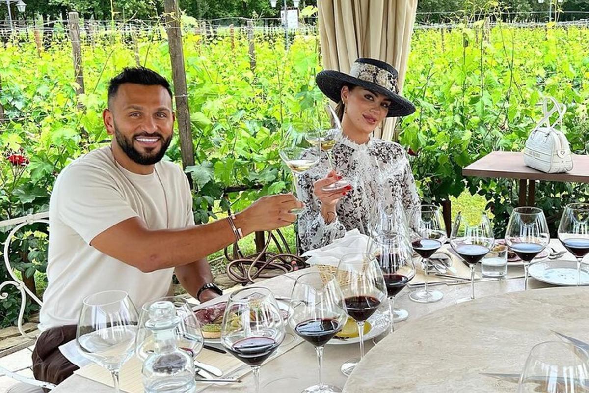 un bărbat și o femeie așezați la o masă cu pahare de vin