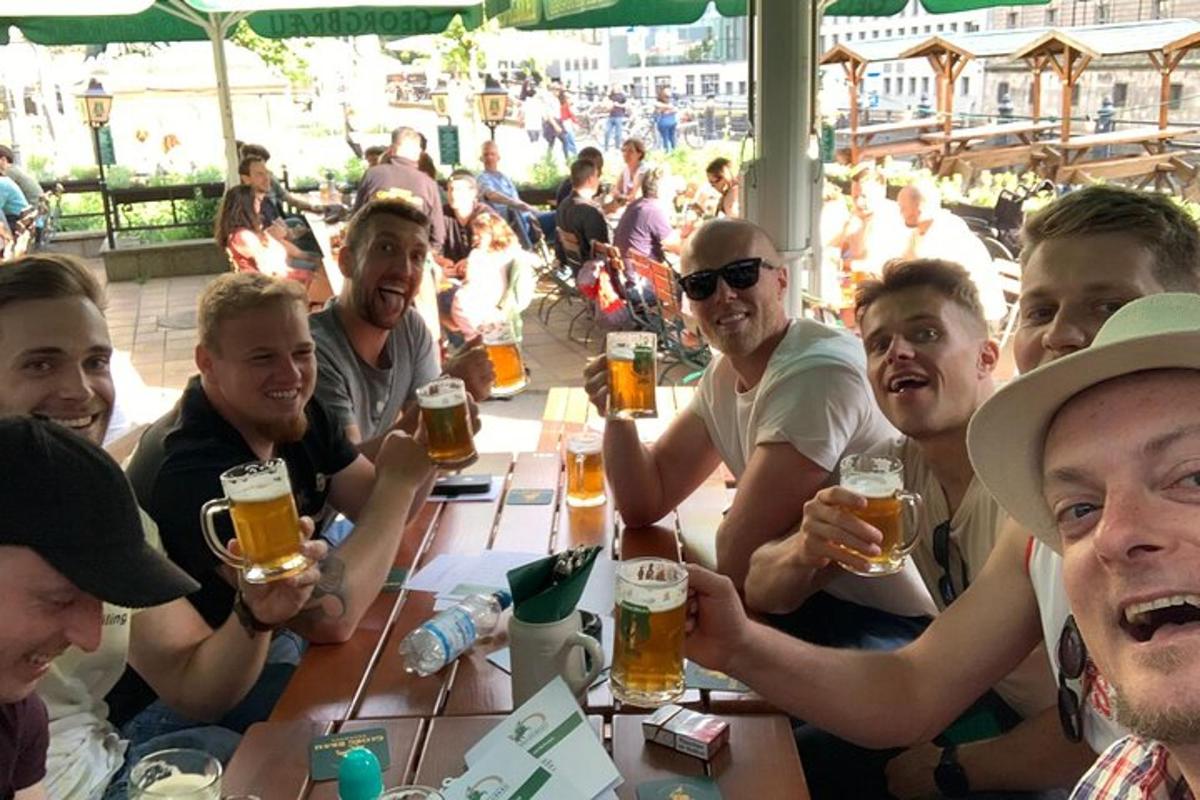 hópur fólks situr við borð og drekkur bjór