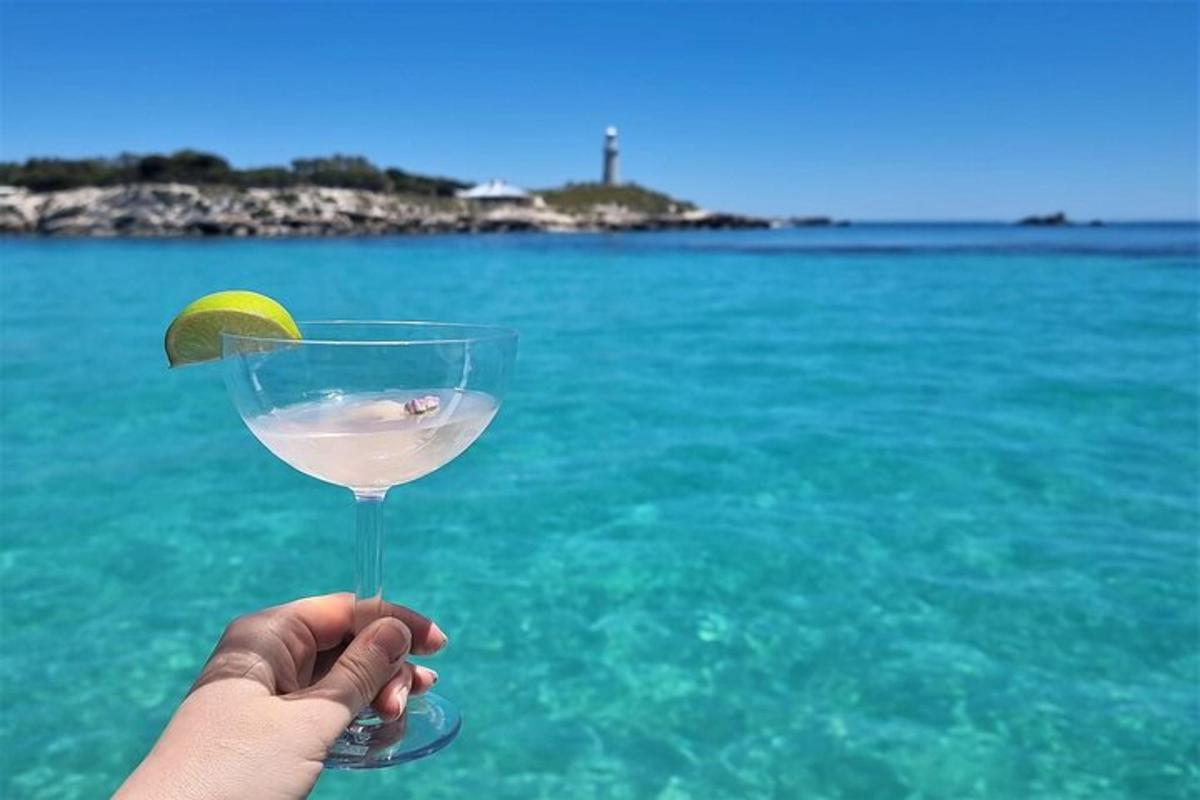 a person holding a glass with a lemon in the water