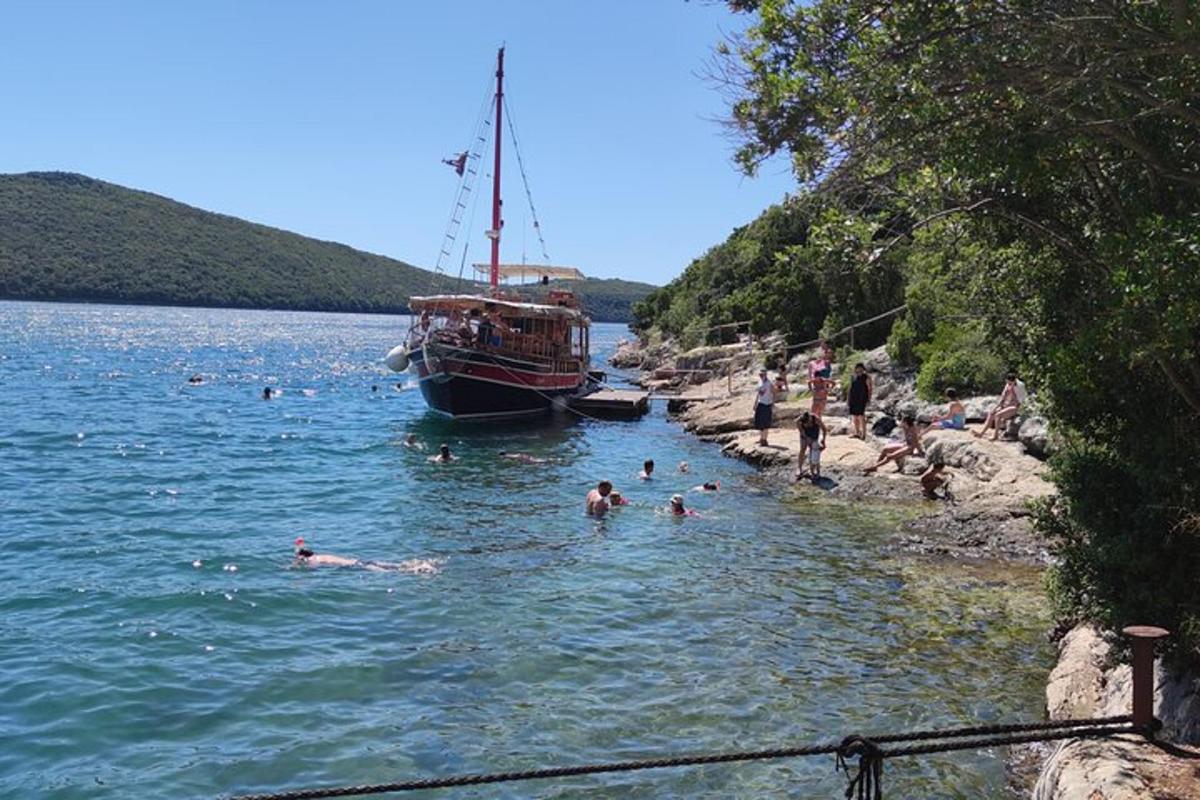 un gruppo di persone che nuotano nell'acqua vicino a una barca