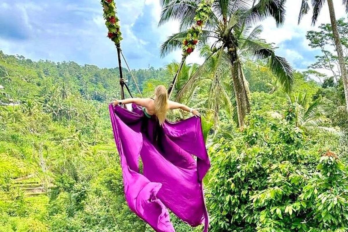 una dona amb un vestit rosa balancejant-se en una hamaca