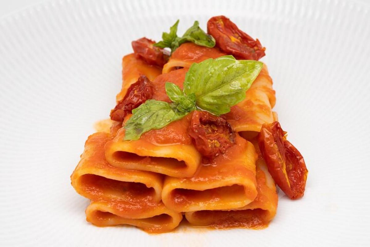 a plate of pasta with basil and bacon