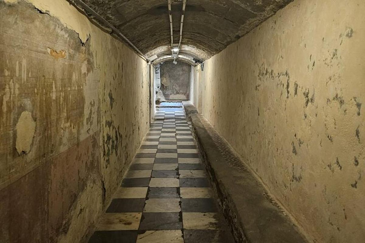 an empty hallway with a checkered floor in a tunnel