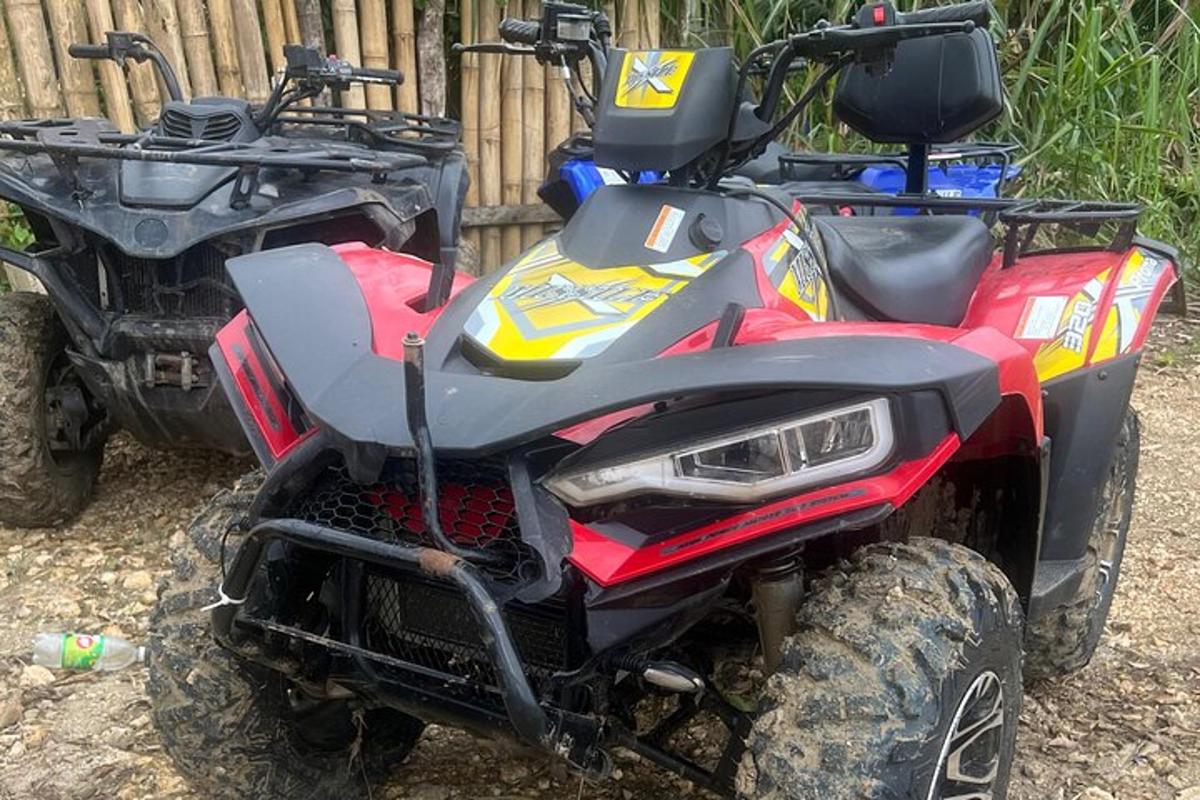 un quad vermell i groc aparcat al costat d'una tanca