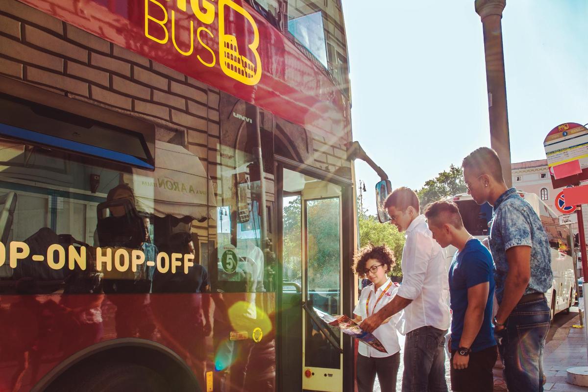 grupa ludzi stojąca przed autobusem