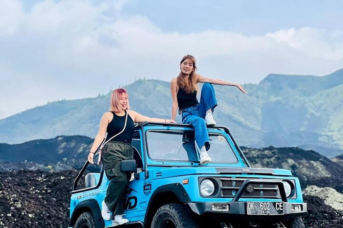 due donne sedute sul tetto di una jeep blu