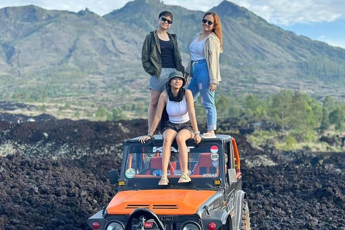 tre persone in piedi sul tetto di una jeep