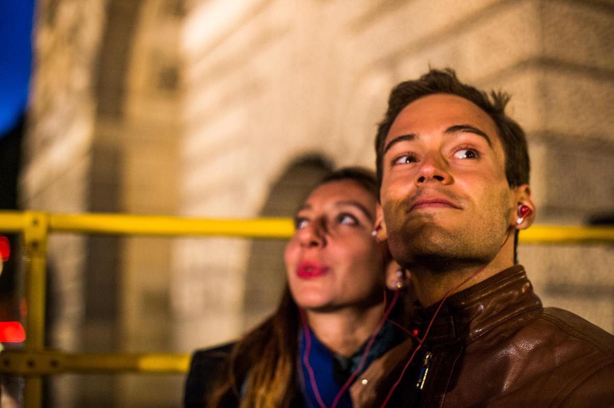 a woman standing next to a man wearing headphones