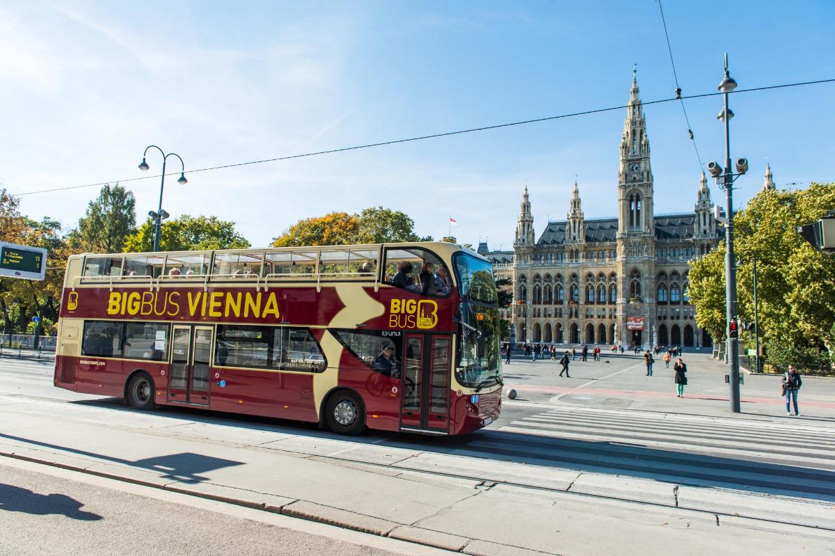 rdeč dvonadstropni avtobus, ki se vozi po ulici