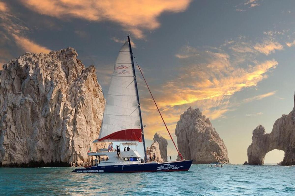 una barca a vela in acqua vicino a una formazione rocciosa