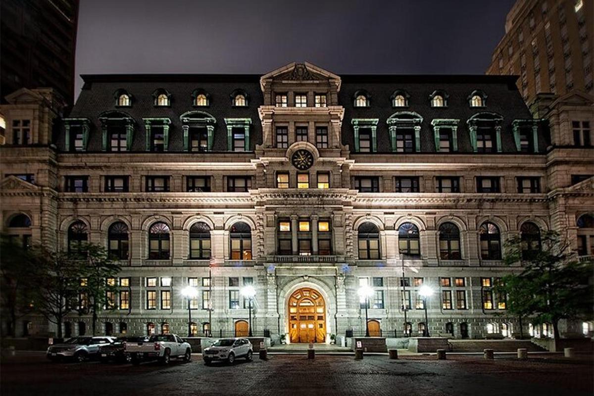 un grand bâtiment avec des voitures garées devant