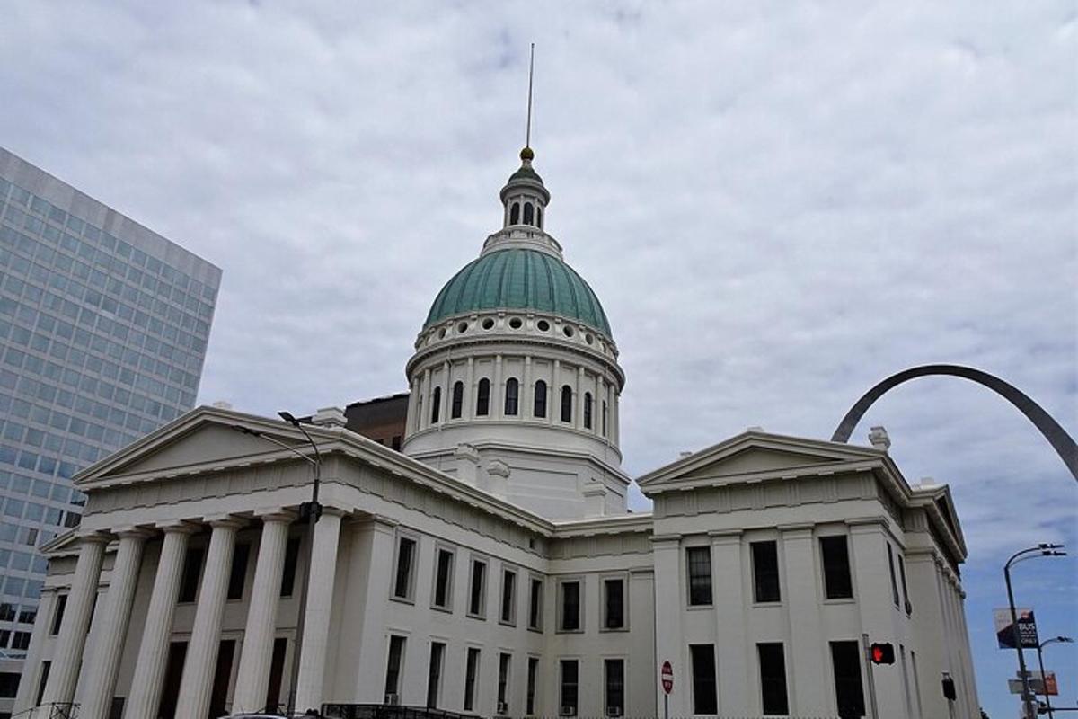a white building with a green dome on top of it