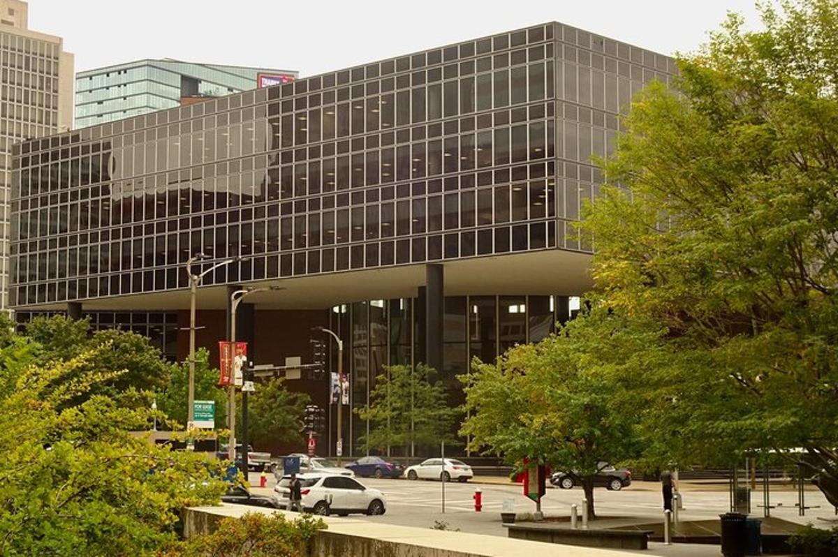 a large glass building with cars parked in a parking lot