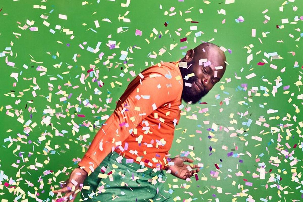 a man in an orange shirt is covered in confetti