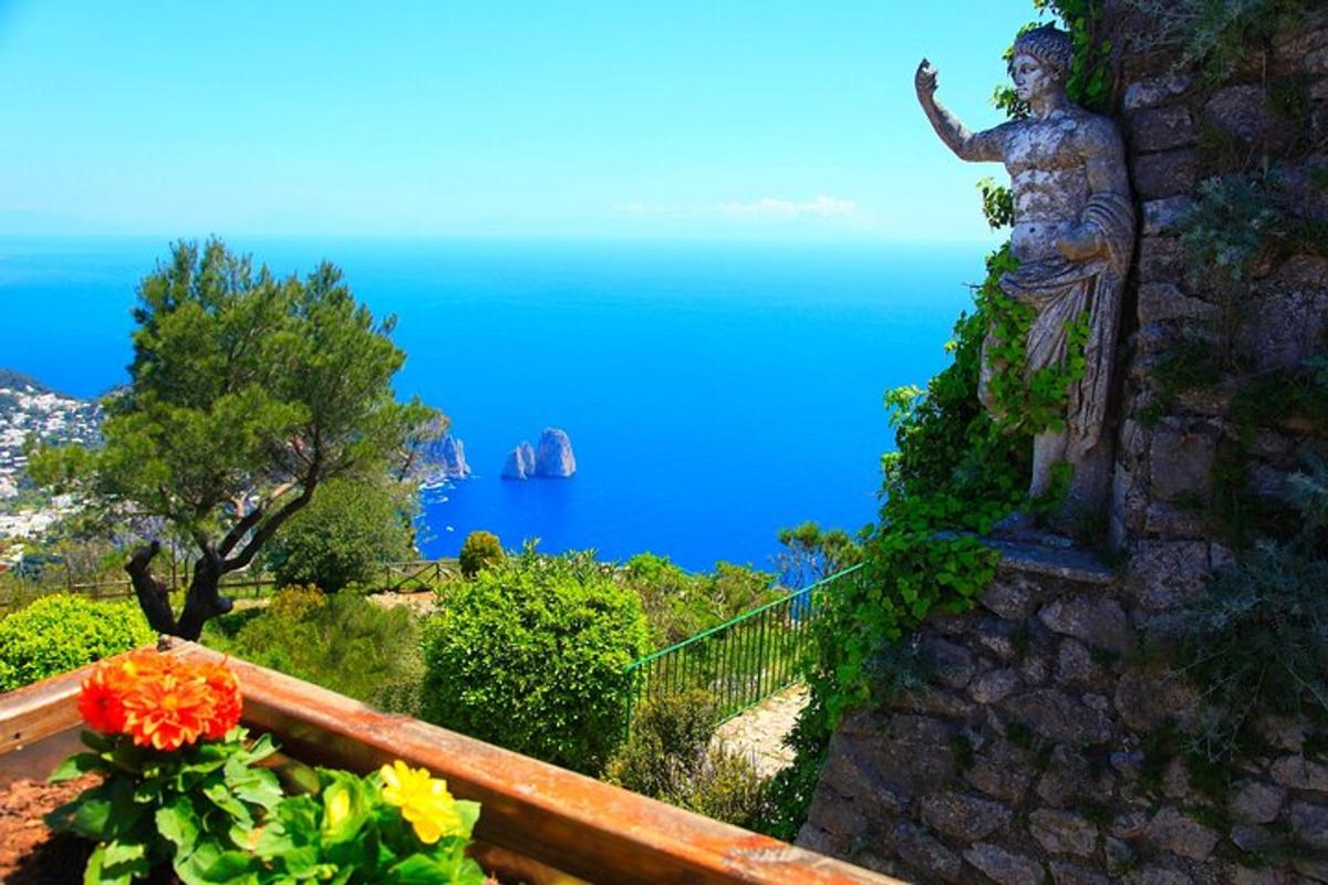 una statua di una donna su un muro con l'oceano
