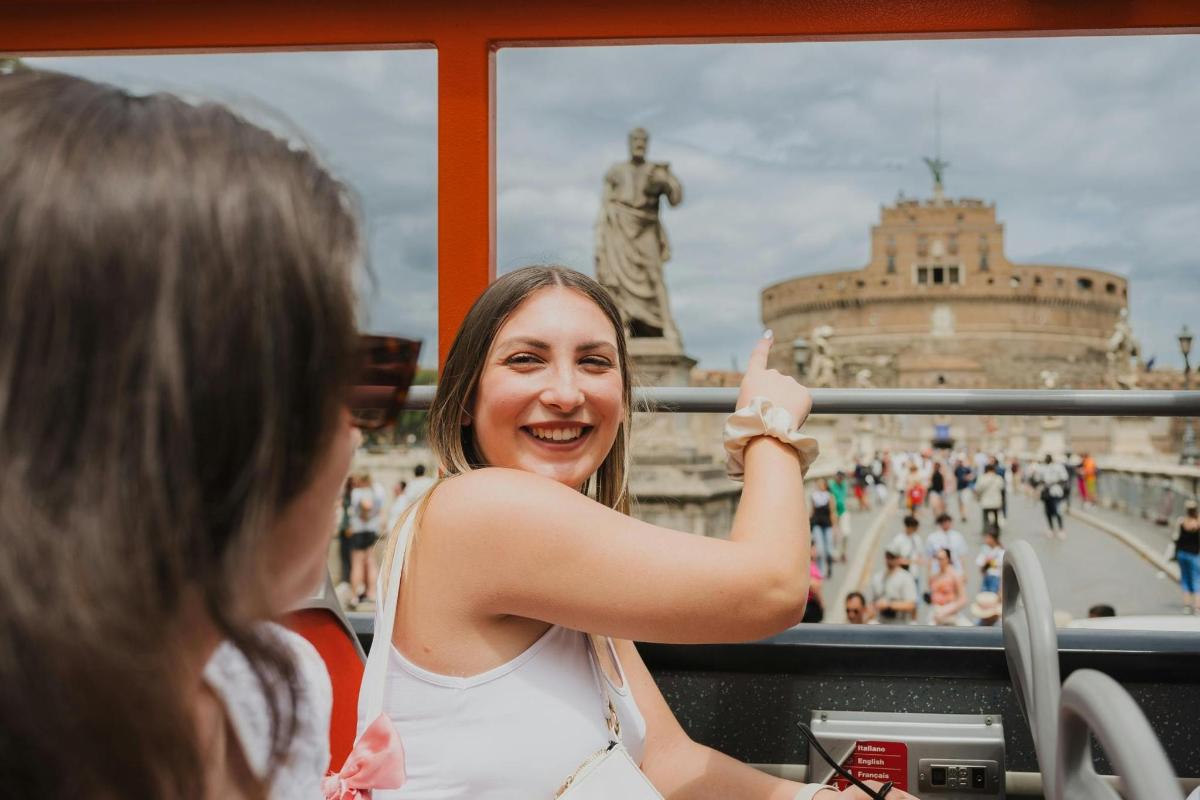 Egy nő fényképez egy buszon a város előtt