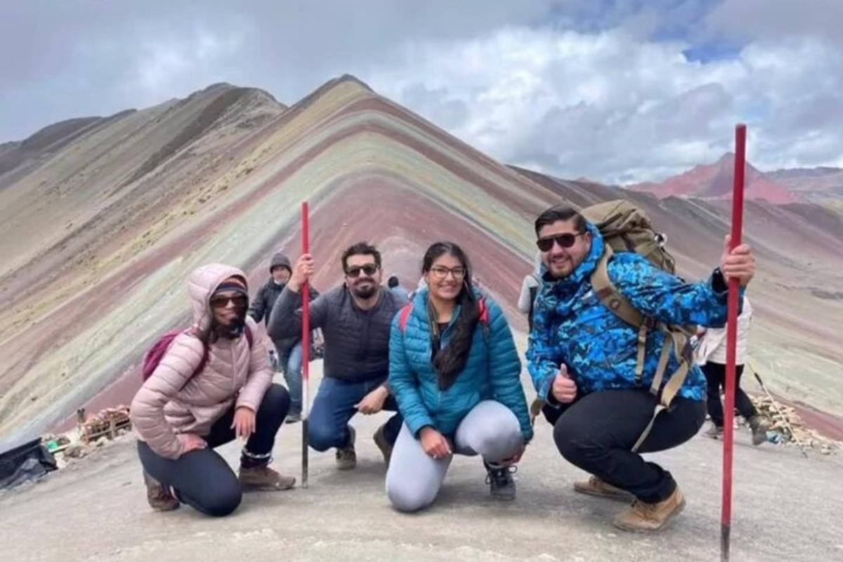 un gruppo di persone in posa davanti a una montagna