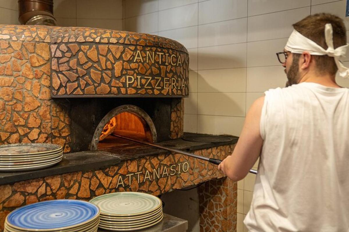 maður stendur fyrir framan pizzaofn